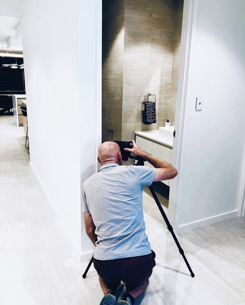 Andrew Pritchard on location, framing an interior shot on a tripod