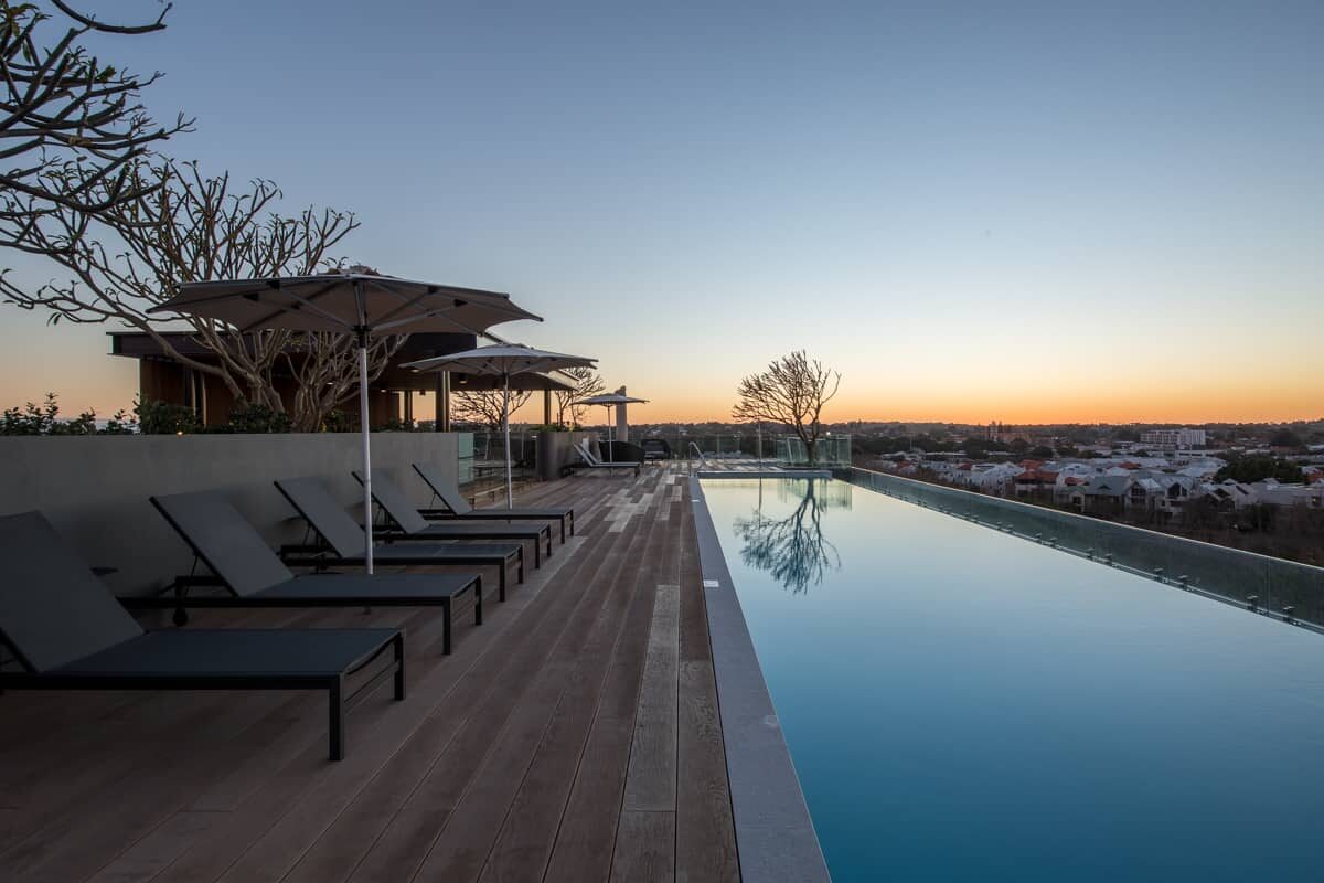 Rooftop infinity pool and sun loungers at dusk